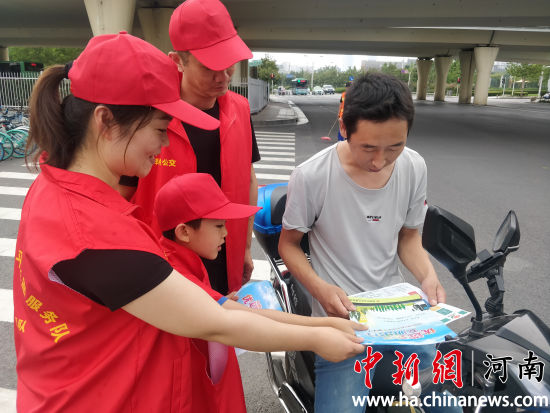 志愿者們?yōu)檫^(guò)往行人發(fā)放綠色出行宣傳單。連柏梁 攝