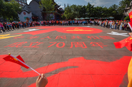成都市民現(xiàn)場繪制400平米巨型地面沙畫獻禮新中國成立70周年